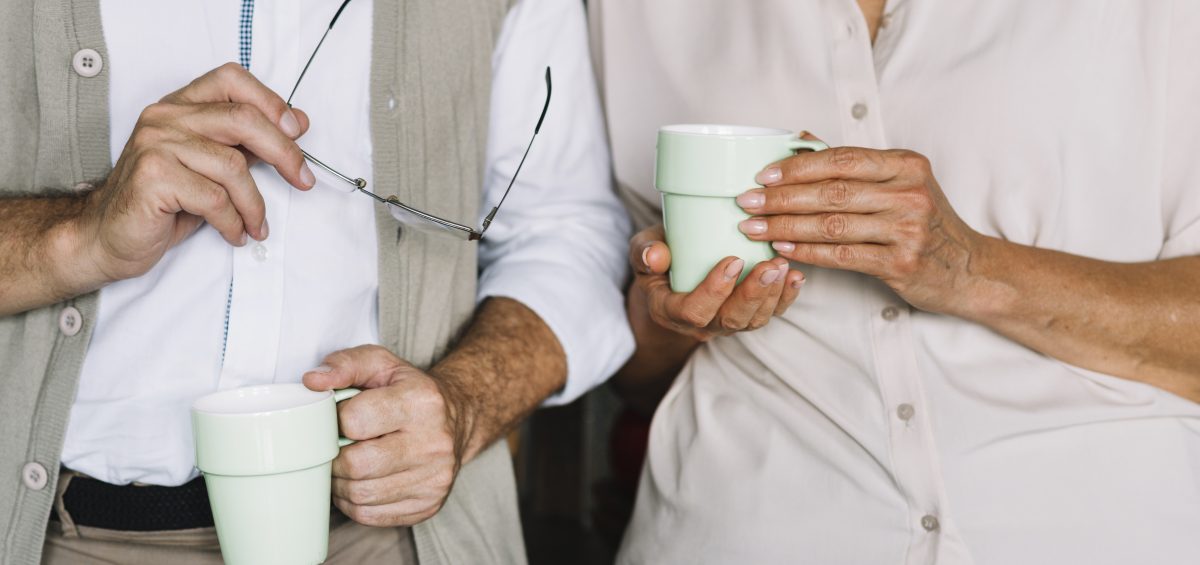 Two people holding coffee cups - Dementia caring