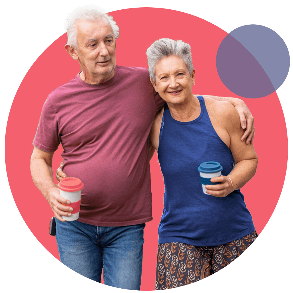 Two older adults walking side by side holding coffee cups