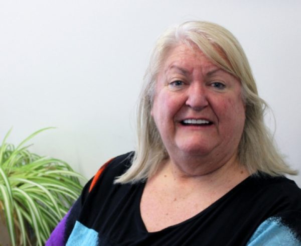 Woman in a caring role smiles at the camera in an office area