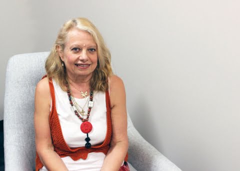Woman in caring role sits in a grey armchair
